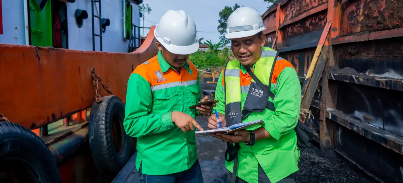 Surveyors reviewing survey data on a tablet aboard a barge
